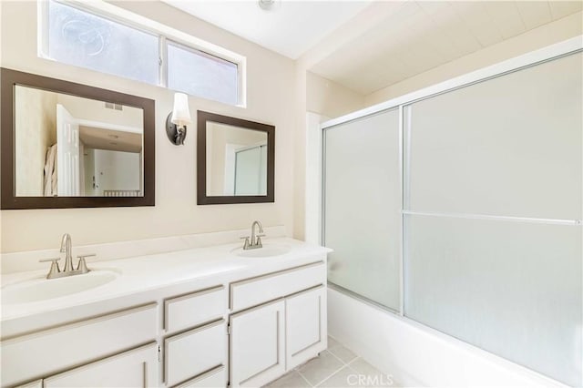 bathroom with a sink, enclosed tub / shower combo, double vanity, and tile patterned floors