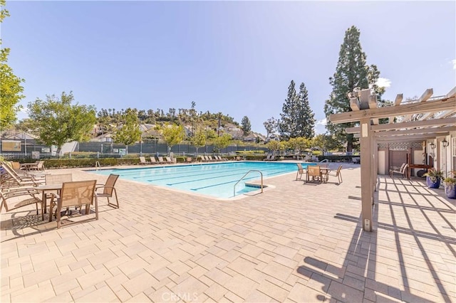 pool with a patio, a pergola, and fence