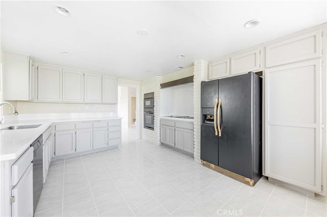 kitchen with a sink, black appliances, recessed lighting, and light countertops