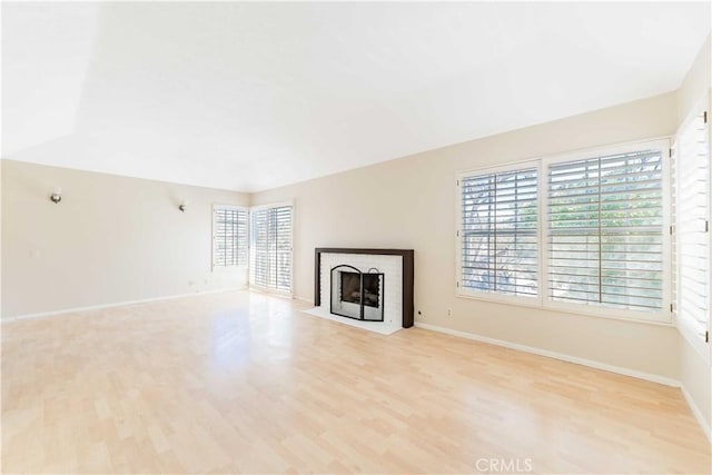 unfurnished living room featuring a fireplace with flush hearth, light wood-style flooring, and baseboards