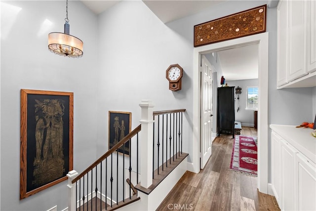 hallway featuring an upstairs landing, dark wood-style floors, and baseboards