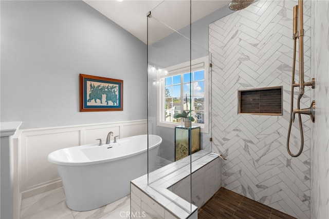 full bathroom with a decorative wall, a soaking tub, wainscoting, and a tile shower