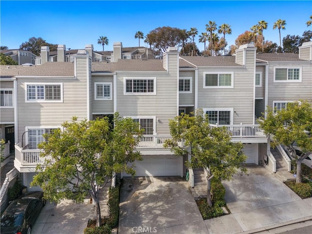 view of front facade featuring a residential view, concrete driveway, and an attached garage