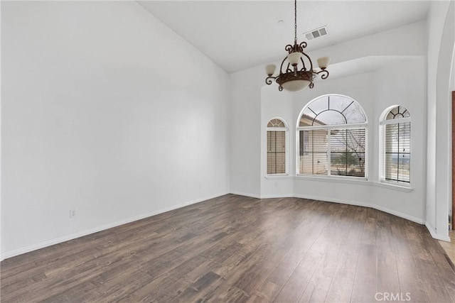 unfurnished dining area featuring baseboards, an inviting chandelier, visible vents, dark wood finished floors, and high vaulted ceiling