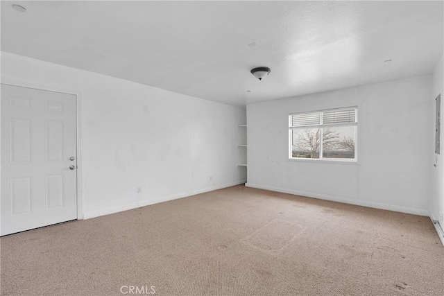 carpeted spare room with baseboards