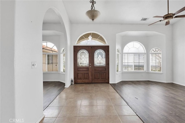 entryway featuring visible vents, baseboards, wood finished floors, and a ceiling fan