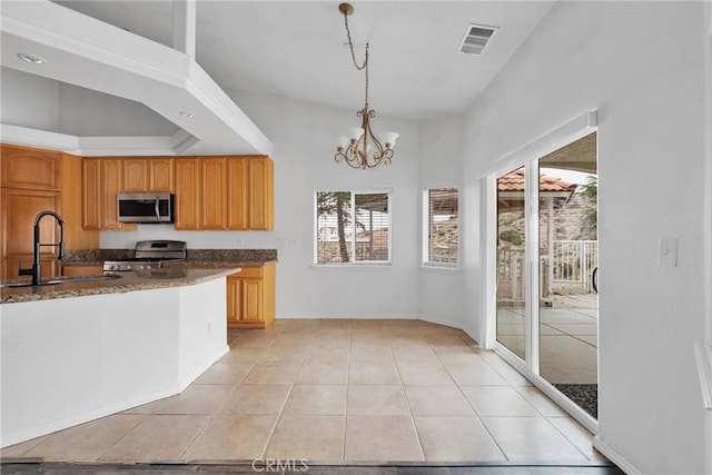 kitchen featuring visible vents, an inviting chandelier, a sink, stainless steel appliances, and pendant lighting