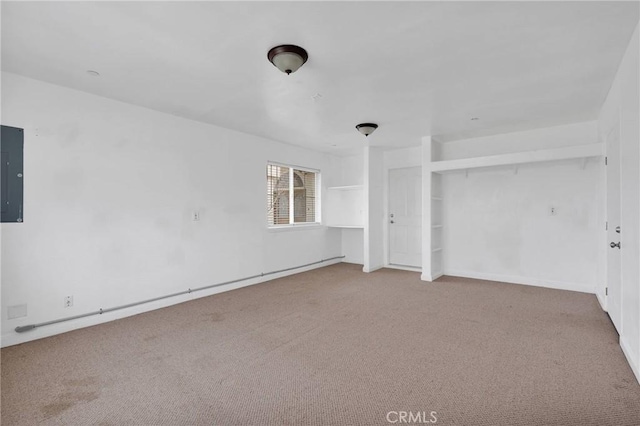 unfurnished bedroom featuring electric panel, carpet flooring, and baseboards