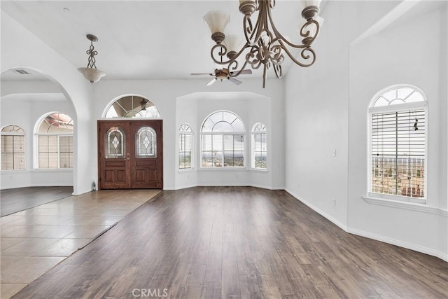 foyer entrance featuring baseboards, an inviting chandelier, and wood finished floors