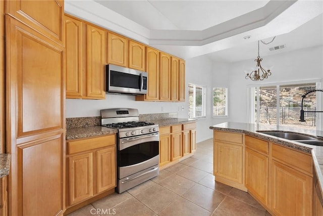 kitchen featuring visible vents, a sink, appliances with stainless steel finishes, stone counters, and light tile patterned floors