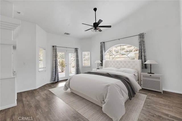 bedroom with multiple windows, wood finished floors, and access to exterior