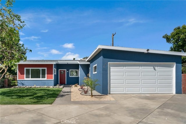 view of front facade with stucco siding, an attached garage, driveway, and a front yard