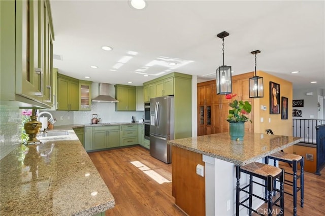 22176 Dogie Pl, Canyon Lake, CA 92587 - kitchen with green cabinets, wall chimney exhaust hood, stainless steel refrigerator with ice dispenser, a breakfast bar, and light wood-style floors