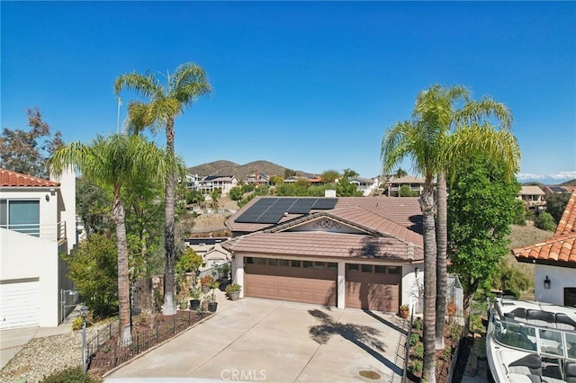 22176 Dogie Pl, Canyon Lake, CA 92587 - view of front facade featuring a tile roof, solar panels, concrete driveway, stucco siding, and a garage