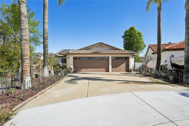 view of front of home featuring a garage, stucco siding, driveway, and fence