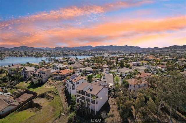 aerial view at dusk featuring a residential view and a water and mountain view