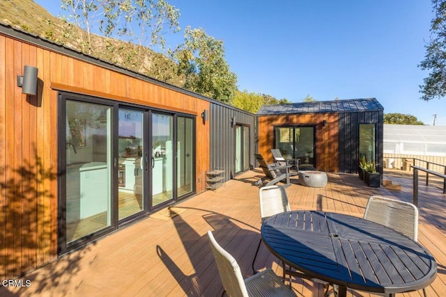 wooden deck with outdoor dining area and an outdoor structure