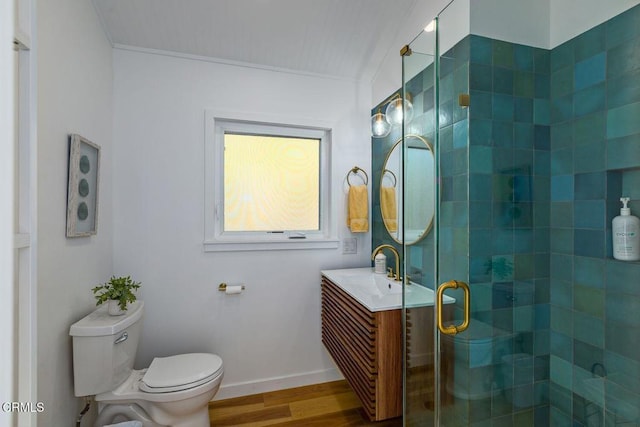 full bath with vanity, wood finished floors, baseboards, a shower stall, and toilet