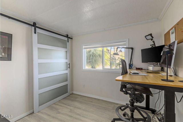 office space with a barn door, baseboards, crown molding, and light wood finished floors