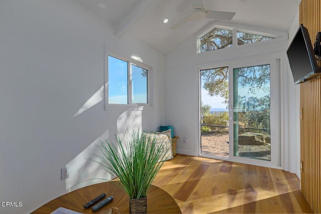 doorway to outside with a wealth of natural light, a ceiling fan, wood finished floors, and vaulted ceiling with beams