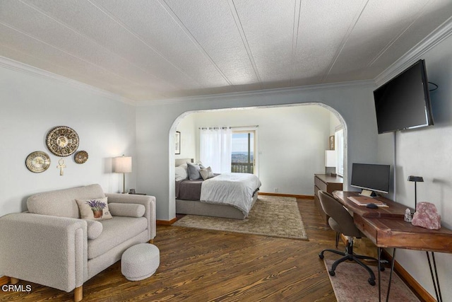 bedroom with crown molding, baseboards, wood finished floors, arched walkways, and a textured ceiling