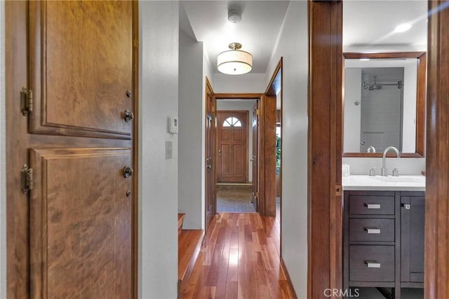 hall featuring hardwood / wood-style floors and a sink