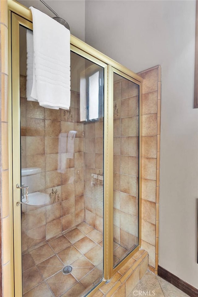 bathroom with a stall shower and baseboards