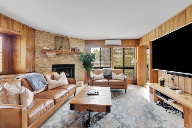 living area with a wall mounted air conditioner, a stone fireplace, wood walls, and light tile patterned floors