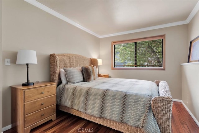 bedroom featuring baseboards, dark wood finished floors, and crown molding