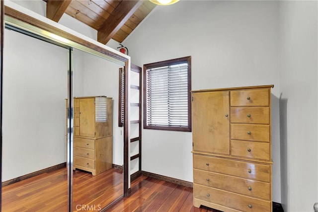 unfurnished bedroom with dark wood finished floors, a closet, baseboards, wood ceiling, and vaulted ceiling with beams