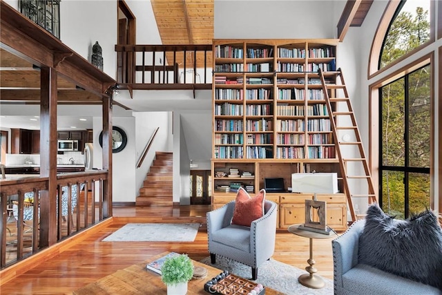 sitting room featuring stairs, wood finished floors, and a towering ceiling