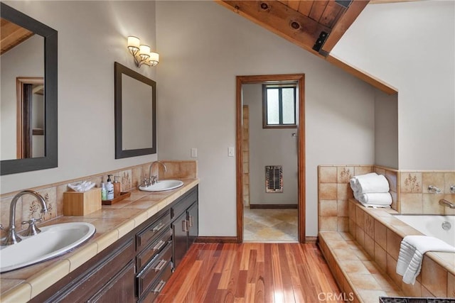 bathroom featuring a sink, lofted ceiling with beams, wood finished floors, and wooden ceiling