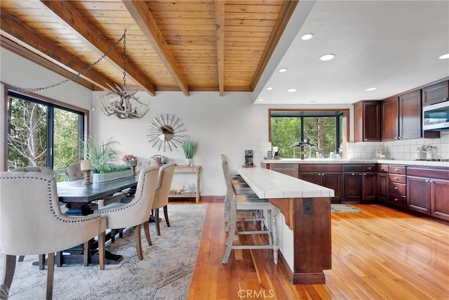 kitchen with stainless steel appliances, plenty of natural light, tile counters, and decorative backsplash