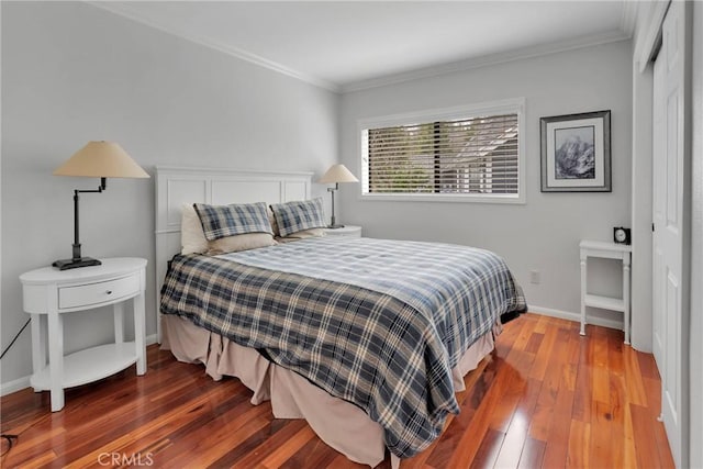 bedroom with hardwood / wood-style flooring, baseboards, and ornamental molding