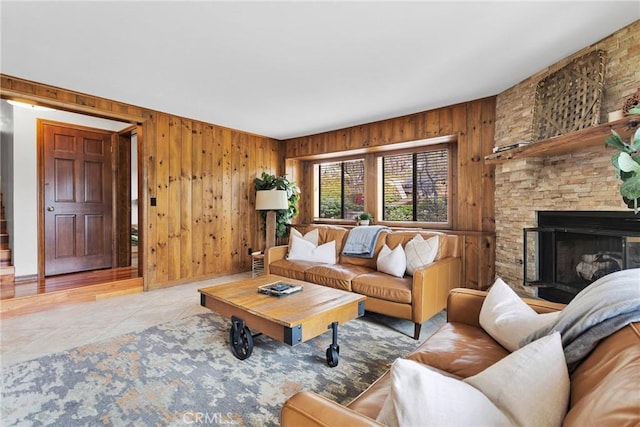 living area featuring tile patterned flooring, a fireplace, and wood walls