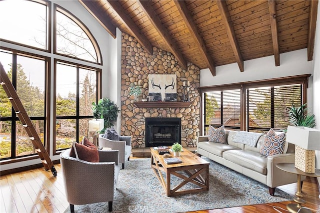 living area featuring high vaulted ceiling, wood ceiling, hardwood / wood-style floors, and a fireplace