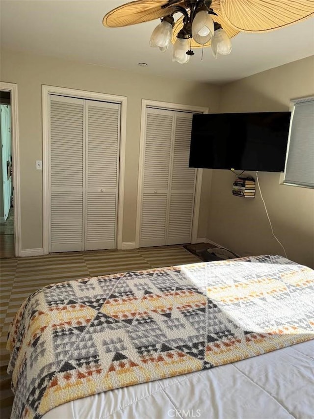 bedroom with ceiling fan, baseboards, and multiple closets