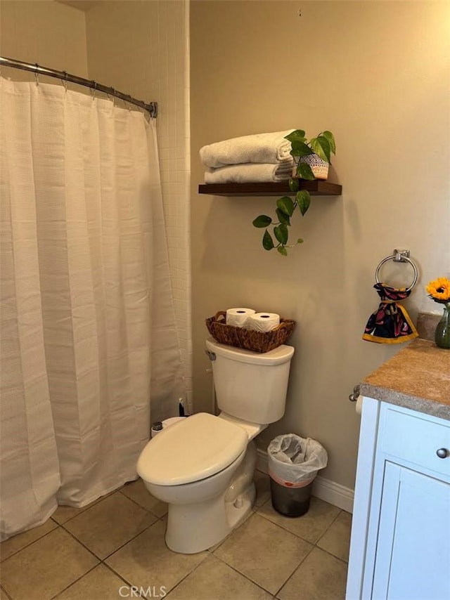 bathroom featuring tile patterned flooring, toilet, vanity, and baseboards