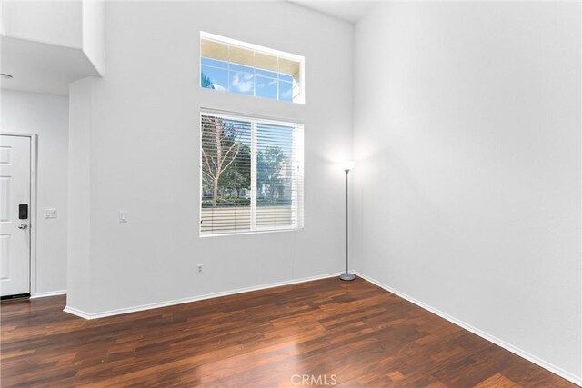 unfurnished room with baseboards and wood finished floors