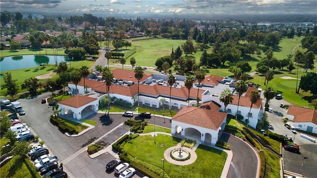 birds eye view of property with golf course view, a water view, and a residential view