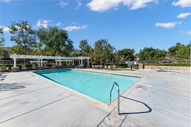 pool with a patio area, a pergola, and fence