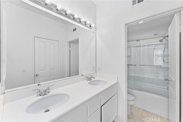 bathroom with double vanity, toilet, visible vents, and a sink