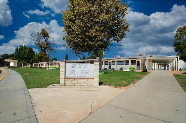 view of front facade with driveway, an attached carport, and a front lawn