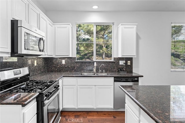 kitchen featuring a sink, decorative backsplash, white cabinetry, and stainless steel appliances