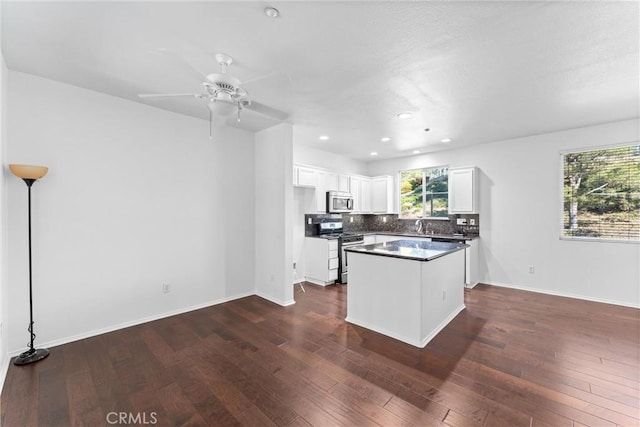 kitchen featuring white cabinets, dark wood-style flooring, backsplash, and stainless steel appliances