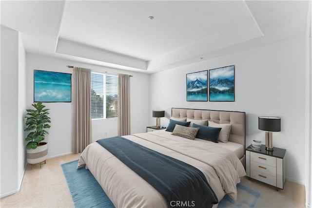 bedroom featuring a tray ceiling, baseboards, and light carpet