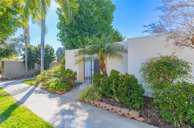 exterior space featuring stucco siding and fence