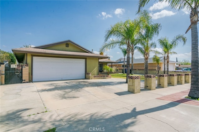 view of front of home featuring concrete driveway, fence, and a gate