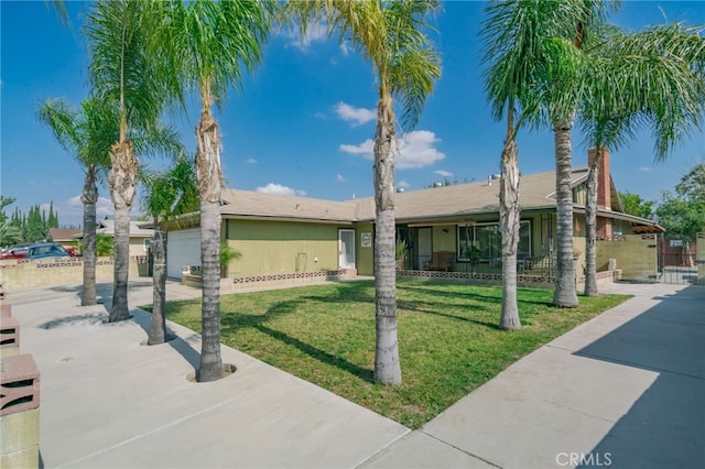 view of front of property featuring a garage, driveway, a front lawn, and fence