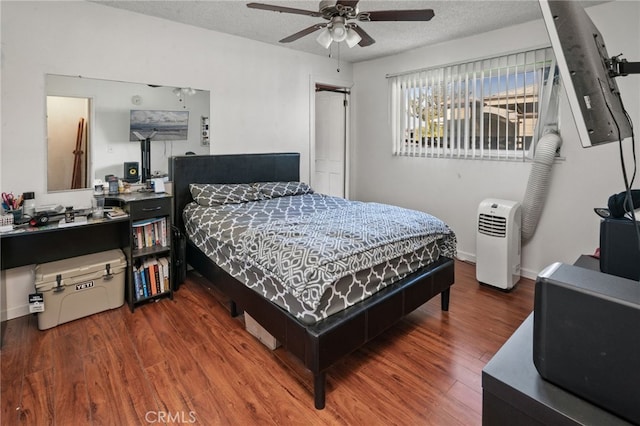 bedroom featuring baseboards, wood finished floors, a closet, a textured ceiling, and a ceiling fan